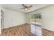Bedroom with wood floors, ceiling fan, and sliding glass door leading to screened patio at 7810 34Th E Ct, Sarasota, FL 34243