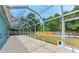 Screened outdoor patio with view of backyard, lawn, and wooden fence at 7810 34Th E Ct, Sarasota, FL 34243
