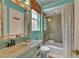 Vintage bathroom features a aqua painted walls, tiled shower and a ornate mirror over the sink at 8105 Warwick Gardens Ln, University Park, FL 34201