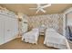 Charming bedroom featuring twin beds and patterned wallpaper, creating a cozy feel at 8105 Warwick Gardens Ln, University Park, FL 34201