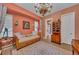 Inviting bedroom featuring coral walls, unique cabinet and comfortable seating area with daybed at 8105 Warwick Gardens Ln, University Park, FL 34201