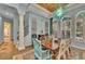 Chic dining room featuring wood flooring, decorative columns and a custom light fixture at 8105 Warwick Gardens Ln, University Park, FL 34201