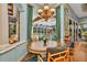 Bright dining room features a decorative chandelier, and a beautiful view of the screened-in pool and backyard at 8105 Warwick Gardens Ln, University Park, FL 34201
