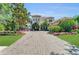 Stunning home featuring a grand entrance, lush landscaping, and a circular driveway at 8105 Warwick Gardens Ln, University Park, FL 34201