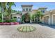 Beautiful home featuring lush landscaping, a brick driveway with a circular grass inlay, and a grand entrance at 8105 Warwick Gardens Ln, University Park, FL 34201