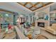 Spacious living room with fireplace, wood-beamed ceiling, and elegant decor at 8105 Warwick Gardens Ln, University Park, FL 34201