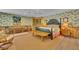Spacious bedroom with tropical wallpaper, bench, and comfortable sitting area at 8105 Warwick Gardens Ln, University Park, FL 34201