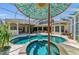 Inviting backyard pool and spa area with lush landscaping and covered outdoor seating at 8105 Warwick Gardens Ln, University Park, FL 34201