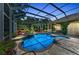 Screened-in pool with a decorative shade umbrella and brick paver patio at 8105 Warwick Gardens Ln, University Park, FL 34201