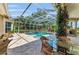 Outdoor patio seating area overlooking screened-in pool with lush landscaping at 8105 Warwick Gardens Ln, University Park, FL 34201