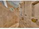 Travertine tiled shower offers multiple shower heads, built-in bench and niche with small window at 8105 Warwick Gardens Ln, University Park, FL 34201