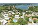 Aerial view of a residential area with serene lake, showcasing houses with pools nestled among lush greenery and trees at 8408 Whispering Woods Ct, Lakewood Ranch, FL 34202