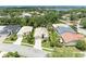 Aerial view of a neighborhood with mature trees and well-maintained homes near a large lake at 8408 Whispering Woods Ct, Lakewood Ranch, FL 34202