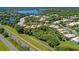 Aerial view of community featuring lush landscaping, a sparkling lake, and well-maintained homes at 8408 Whispering Woods Ct, Lakewood Ranch, FL 34202
