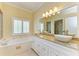 Bright bathroom features dual vessel sinks, soaking tub and granite counters at 8408 Whispering Woods Ct, Lakewood Ranch, FL 34202