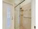 Glass enclosed shower features tile surround with built in shelves and a seat at 8408 Whispering Woods Ct, Lakewood Ranch, FL 34202