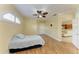 Bedroom with hardwood floors, ceiling fan, and views into the kitchen and living room at 8408 Whispering Woods Ct, Lakewood Ranch, FL 34202