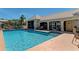 Community pool surrounded by building and greenery, offering lounge seating and a refreshing oasis at 8408 Whispering Woods Ct, Lakewood Ranch, FL 34202