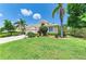 Lovely home features a green lawn with mature landscaping and lush tropical foliage at 8408 Whispering Woods Ct, Lakewood Ranch, FL 34202