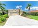 Beautiful single-story home with a well-manicured lawn, mature landscaping, and a spacious driveway at 8408 Whispering Woods Ct, Lakewood Ranch, FL 34202