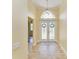 Inviting foyer featuring tile flooring, decorative double doors, and elegant lighting fixture at 8408 Whispering Woods Ct, Lakewood Ranch, FL 34202