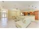 Bright living room featuring tile floors, a comfortable sofa, and an open view to the kitchen at 8408 Whispering Woods Ct, Lakewood Ranch, FL 34202