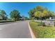 Street view of a well-maintained road lined with lush greenery, stone-clad walls, and manicured hedges in a neighborhood at 8408 Whispering Woods Ct, Lakewood Ranch, FL 34202