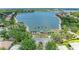 Picturesque view of a serene lake with a charming gazebo, complemented by lush greenery and neighborhood homes at 8408 Whispering Woods Ct, Lakewood Ranch, FL 34202