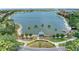 Picturesque view of a serene lake with a charming gazebo, complemented by lush greenery and neighborhood homes at 8408 Whispering Woods Ct, Lakewood Ranch, FL 34202