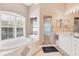 Bright bathroom features a soaking tub with plantation shutters and a glass-enclosed shower at 8604 15Th Nw Ave, Bradenton, FL 34209