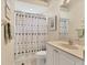 Bathroom with shower featuring a seashell-themed curtain, sink, and white cabinets at 8604 15Th Nw Ave, Bradenton, FL 34209