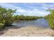 Sandy beach next to a calm body of water at 8604 15Th Nw Ave, Bradenton, FL 34209