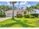 Landscaped front yard of home with lush green lawn and beautiful tropical plants creates curb appeal at 8604 15Th Nw Ave, Bradenton, FL 34209