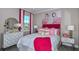 Inviting bedroom featuring vibrant pink accents, flamingo art, and a lovely mirror above a modern dresser at 8633 Snowfall St, Sarasota, FL 34241
