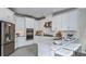 Modern kitchen featuring white cabinets, stainless steel appliances, and a breakfast bar with seating at 8633 Snowfall St, Sarasota, FL 34241