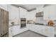 Modern kitchen with white cabinets, granite countertops, stainless steel appliances, and gray tile floors at 8633 Snowfall St, Sarasota, FL 34241