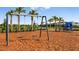 Swings and slide equipment at a playground area surrounded by mulch and fencing at 8633 Snowfall St, Sarasota, FL 34241