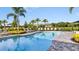 Sparkling community pool surrounded by lounge chairs and palm trees offers a relaxing escape at 8633 Snowfall St, Sarasota, FL 34241