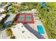 Aerial view of community tennis courts and pool facility near parking area, docks and water at 9409 Catalina Dr, Bradenton, FL 34210
