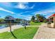 The backyard boasts lush green grass, an in-water boat lift, and a pathway made with brick pavers and a grill at 9409 Catalina Dr, Bradenton, FL 34210