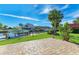 The backyard boasts lush green grass, an in-water boat lift, and a pathway made with brick pavers at 9409 Catalina Dr, Bradenton, FL 34210