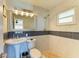 Bright bathroom with a pedestal sink, stylish mirror, and walk-in shower featuring attractive tile work at 9409 Catalina Dr, Bradenton, FL 34210