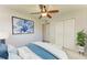 Bedroom featuring a large blue art piece, spacious closet, and a comfortable queen-size bed with white accents at 9409 Catalina Dr, Bradenton, FL 34210