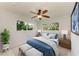 Bright bedroom featuring a ceiling fan, large windows, and a comfortable queen-size bed with blue accents at 9409 Catalina Dr, Bradenton, FL 34210