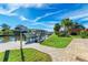 Beautiful waterfront home featuring a private boat dock and walkway leading to a paved patio for outdoor enjoyment at 9409 Catalina Dr, Bradenton, FL 34210