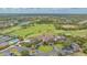 Expansive aerial view of golf course, clubhouse, pool, tennis courts, and parking at 9620 Club South Cir # 5304, Sarasota, FL 34238