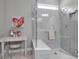 A well-lit bathroom featuring a glass enclosed shower, a small desk, and neutral gray tones at 10414 Spring Tide Way, Parrish, FL 34219
