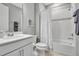 Neutral bathroom with white cabinets, a shower with white tiling, and chrome fixtures at 10414 Spring Tide Way, Parrish, FL 34219