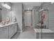 This bathroom features a glass-enclosed shower, dual sinks, and modern lighting at 10414 Spring Tide Way, Parrish, FL 34219
