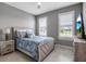 Comfortable bedroom with neutral walls, shuttered windows and coastal themed bedding at 10414 Spring Tide Way, Parrish, FL 34219